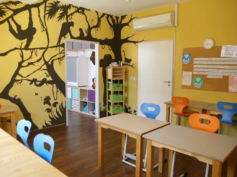 Heller Spiel- und Lernraum der Schulpiraten mit Wandbild, Büchern und Kindertischen